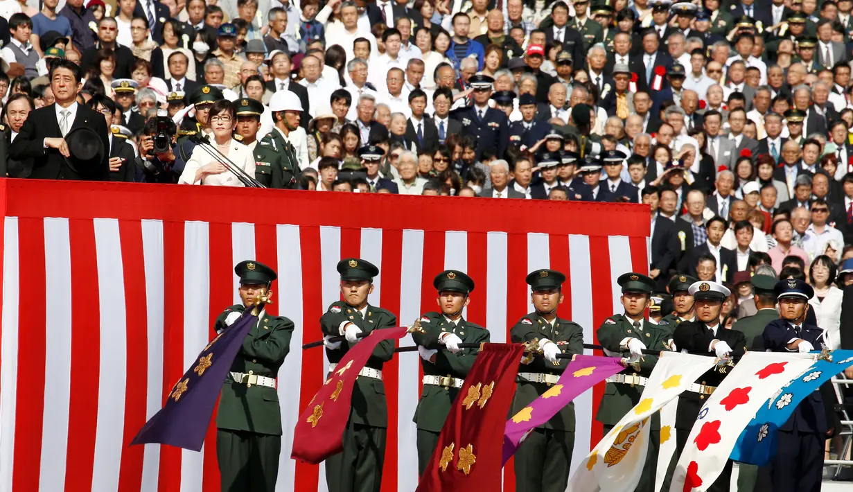 Perdana Menteri Jepang Shinzo Abe (kiri) dan Menteri Pertahanan Tomomi Inada saat menghadiri upacara tahunan Pasukan Bela Diri (SDF) di Pangkalan Asaka, Jepang(23/10). (Reuters/Kim Kyun-Hoon)