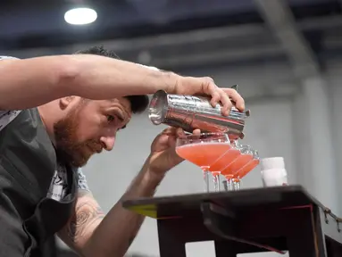 Bartender Mariano Gil menyajikan minuman saat berkompetisi dalam Shake It Up Flair Competition pada hari kedua dari Nightclub & Bar Convention and Trade Show tahunan ke-34 di Las Vegas, Nevada (26/3). (AFP Photo/Ethan Miller)