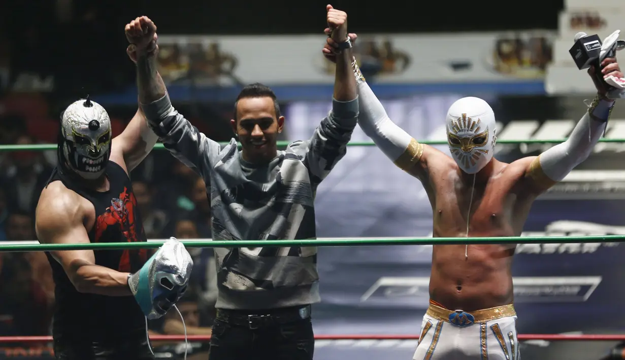 Pebalap F1 dari tim Mercedes GP, Lewis Hamilton bersama bintang WWE di Coliseo Arena, Mexico City, (28/10/2015). (Reuters/Henry Romero)