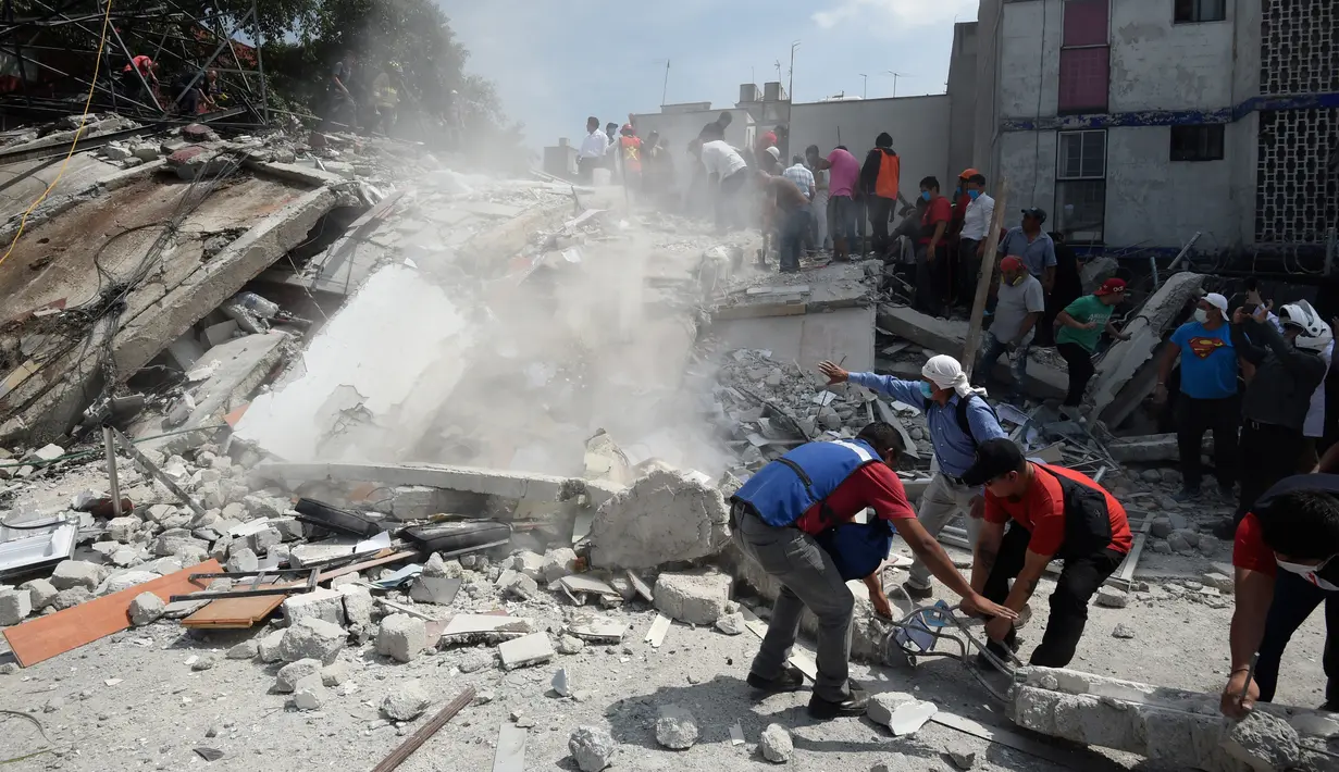 Sejumlah orang memindahkan puing-puing bangunan untuk mencari korban akibat gempa 7,1 SR di Mexico City, Meksiko, Selasa (19/9). Gempa terjadi tepat 32 tahun sejak gempa dahsyat menewaskan ribuan orang di Mexico City pada 1985. (Alfredo ESTRELLA/AFP)