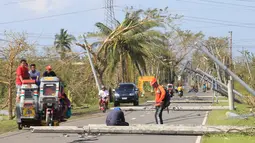 Sejumlah kendaraan melewati tiang listrik yang roboh akibat angin kencang yang disebabkan Topan Nock-ten di Kota Iriga Camarines Sur, Filipina tengah (27/12). Topan Nock-ten atau dikenal dengan Nina menerjang Filipina saat Natal. (REUTERS/Romeo Ranoco)