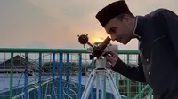 Seorang pengurus sedang mengami hilal dengan alat bantu teropong di Observatorium Assalam, Kamis (23/4).(Liputan6.com/Fajar Abrori)