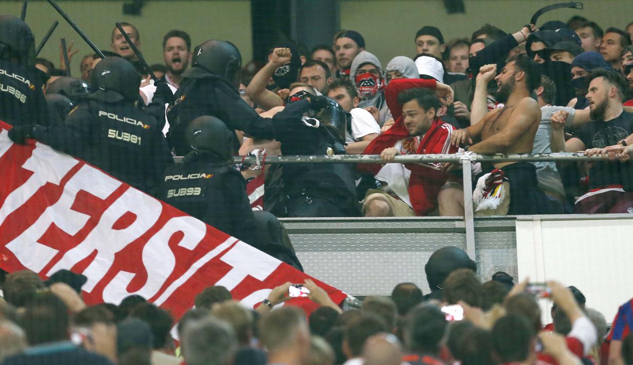 Polisi dan suporter Bayern Munchen terlibat baku hantam saat laga Real Madrid melawan Bayern pada leg kedua perempatfinal Liga Champions di Santiago Bernabeu stadium, Madrid, (18/4/2017). Real Madrid menang 4-2. (AP/Francisco Seco)