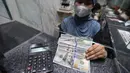 Karyawan menunjukkan uang pecahan dolar Amerika Serikat (AS) di salah satu gerai penukaran mata uang asing, Jakarta, Rabu (5/5/2026). Bank Indonesia (BI) resmi akan memperketat pembatasan pembelian dolar AS tanpa dokumen pendukung (underlying). (Kapanlagi.com/Budy Santoso)