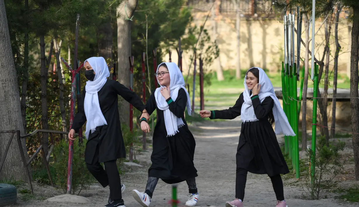 Anak perempuan tiba setelah sekolah mereka dibuka kembali di Kabul, Rabu (23/3/2022). Pembukaan kembali sekolah menengah untuk anak perempuan di seluruh Afghanistan memicu kegembiraan dan ketakutan puluhan ribu siswa yang kehilangan pendidikan sejak Taliban kembali berkuasa. (Ahmad SAHEL ARMAN/AFP)