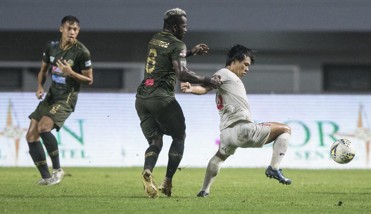 Gelandang Tira Persikabo, Essengue Parfait, menarik baju gelandang Persela Lamongan, Kei Hirose, pada laga Liga 1 di Stadion Pakansari, Bogor, Senin (16/12). Kedua klub bermain imbang 1-1. (Bola.com/Vitalis Yogi Trisna)