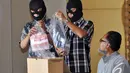 Penyidik KPK menunjukan kantong plastik berisi uang dalam gelar barang bukti terkait operasi tangkap tangan kasus gratifikasi Ketua Dewan Perwakilan Rakyat Daerah Bangkalan KH.Fuad Imron, Selasa (2/12/2014). (Liputan6.com/Miftahul Hayat)