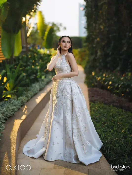 Untuk momen resepsi, Mahalini memilih gaun halterneck rancangan Hian Tjen yang super cantik. Hian Tjen terinspirasi melodi yang merdu saat merancang gaun untuk Mahalini Raharja. Sebuah gaun halter neck berwarna cerah dihiasi dengan manik-manik menghadirkan kesan anggun dan rumit sekaligus.  [@axioo]