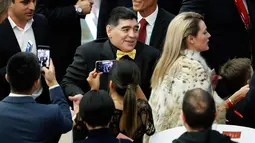 Legenda sepak bola Argentina Diego Maradona ditemani kekasihnya, Rocio Oliva saat menghadiri undian Piala Dunia 2018 di Moskow, Rusia (1/12). (AP Photo/Pavel Golovkin)