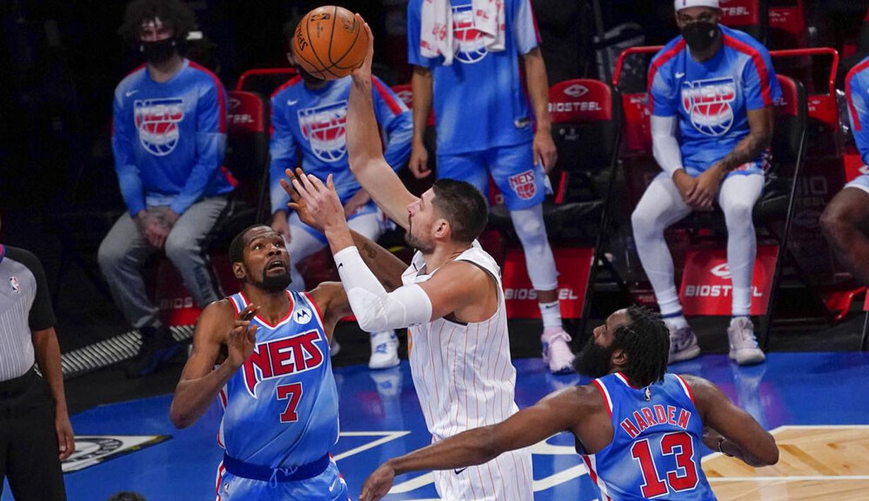 Pebasket Brooklyn Nets, James Harden, berusaha menghalau pebasket Orlando Magic, Nikola Vucevic, pada laga NBA, Sabtu (16/1/2021). Nets menang dengan skor 122-115. (AP Photo/Mary Altaffer)