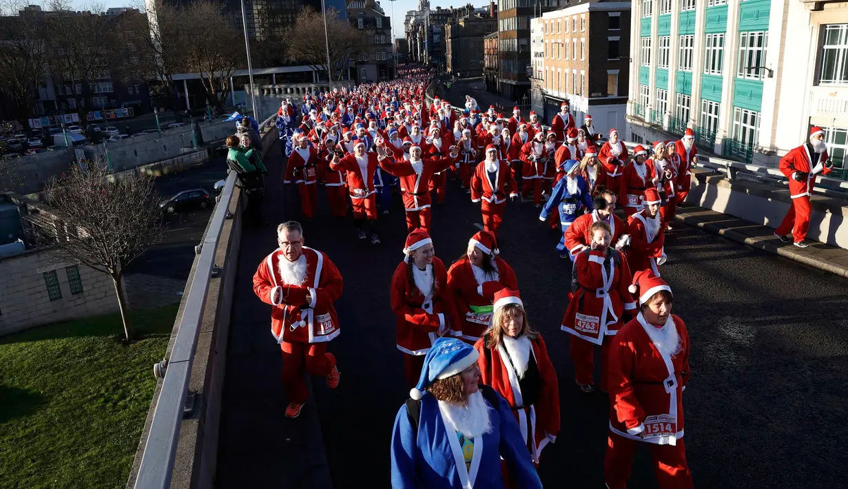 Ribuan peserta mengenakan kostum Santa Claus mengikuti balap lari Santa Dash di Liverpool, Inggris, Minggu (4/12). Lomba lari ini diselenggarakan untuk menyambut datangnya Hari Natal. (Reuters/Phil Noble)