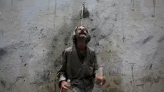 Seorang pria mendinginkan kepalanya di kucuran air keran usai mengisi botol saat cuaca panas yang ekstrem di Karachi, Pakistan, (23/6/2015). Gelombang panas yang telah menewaskan lebih dari 400 jiwa di kota selatan Pakistan. (REUTERS/Akhtar Soomro)