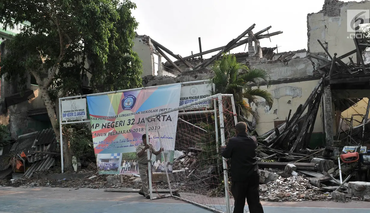 Guru memindahkan gawang di dekat bangunan yang ambruk di SMP Negeri 32, Pejagalan, Tambora, Jakarta, Selasa (14/8).  Setelah ambruk pada akhir tahun lalu gedung SMPN 32 kini sangat memprihatinkan.(Merdeka.com/ Iqbal S. Nugroho)