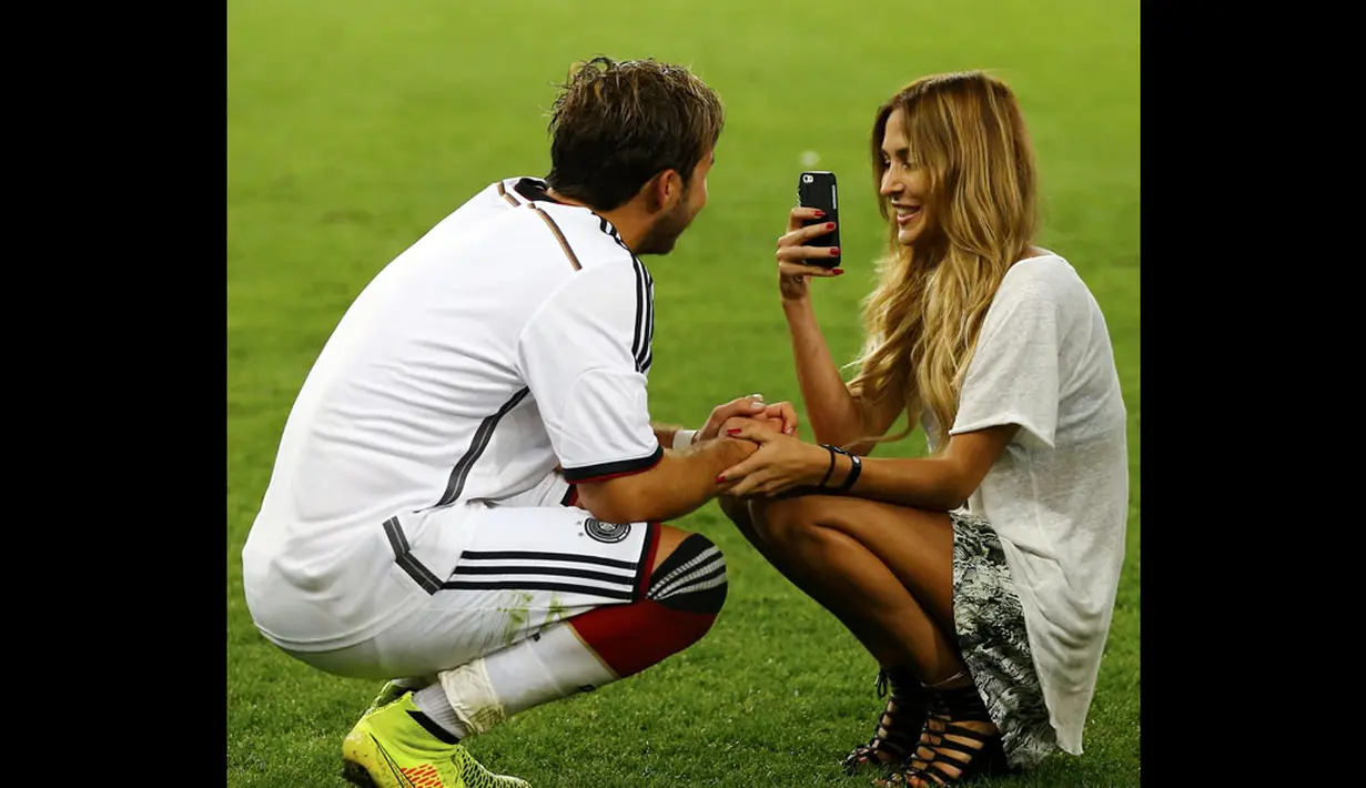 Pemain tengah Timnas Jerman, Mario Goetze (kiri), bercengrama bersama kekasihnya, Ann-Kathrin Brommel, disela-sela selebrasi juara Piala Dunia 2014, Brasil, (14/7/2014). (REUTERS/Darren Staples)