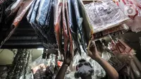 Abdullah merapikan kantong ramah lingkungan yang juga dijual di Pasar Tebet Barat, Jakarta, Selasa (30/6/2020). Meski dirinya juga telah menjual kantong ramah lingkungan, namun minat beli masyarakat tetap masih rendah. (merdeka.com/Iqbal S Nugroho)