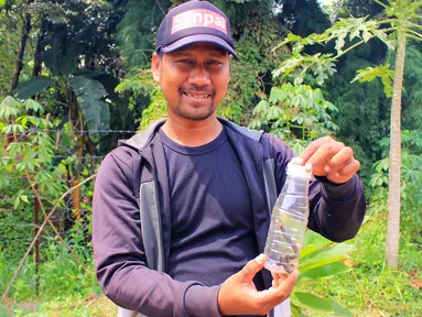 Petugas keamanan Perumahan Citayam Village, Anwar Irawan memperlihatkan anak ular kobra yang  ditangkap warga saat kerja bakti di Kab. Bogor, Sabtu (14/12/2019). Kerja bakti untuk membersihkan lingkungan sekaligus melakukan penyisiran pencarian induk ular kobra. (merdeka.com/Magang/Muhammad Fayyadh)