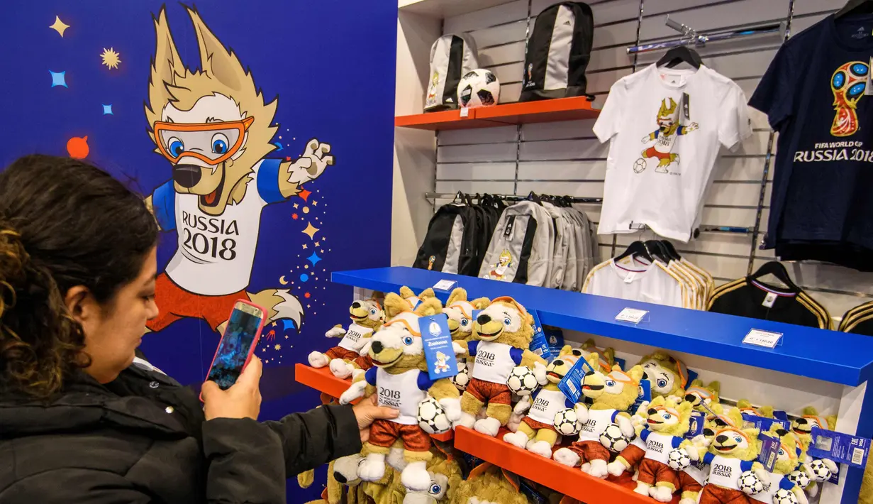 Pengujung mengambil foto maskot turnamen Piala Dunia 2018 'Zabivaka' di toko barang resmi FIFA World Cup 2018 yang dibuka di Central Children's Store di Moskow, Rusia (18/12). (AFP Photo/Mladen Antonov)