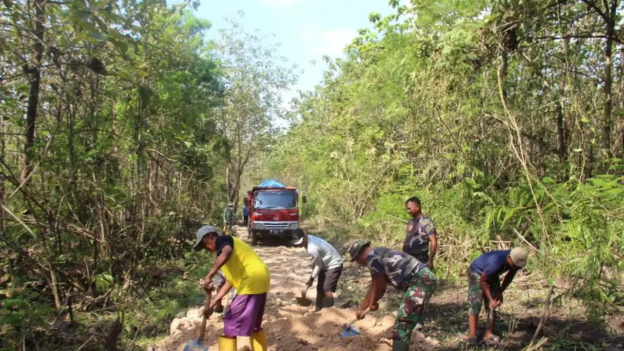 Anggota TNI dari Kodim 0721/Blora saat berjibaku bersama masyarakat dalam kegiatan TMMD ke-113 membangun jalan hutan menuju Dukuh Alas Malang, Desa Pengkoljagong, Kecamatan Jati, Kabupaten Blora. (Liputan6.com/Ahmad Adirin)