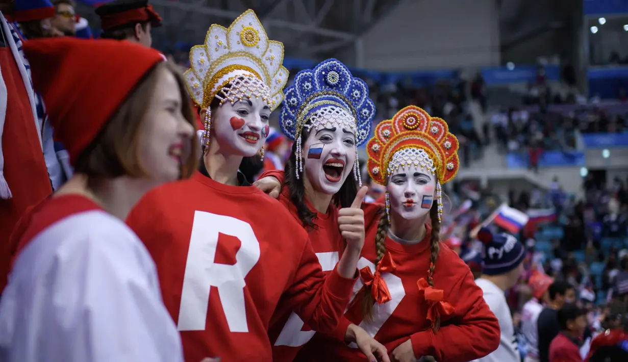 Fans wanita Rusia bersorak sebelum pertandingan penyisihan hoki es grup B antara Rusia dan Amerika Serikat pada Olimpiade Musim Dingin Pyeongchang 2018 di Gangneung Hockey Centre di Gangneung (17/2). (AFP Photo/Ed Jones)
