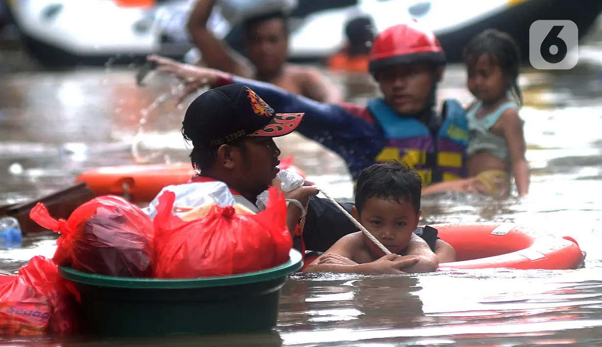 Petugas Pemadam Kebakaran mengevakuasi anak-anak korban banjir dengan menggunakan ban di kawasan Karet Pasar Baru Barat, Jakarta, Selasa (25/2/2020). Banjir yang terjadi sejak subuh akibat luapan Kanal Banjir Barat tersebut merendam ratusan rumah hingga setinggi dua meter. (merdeka.com/Arie Basuki)