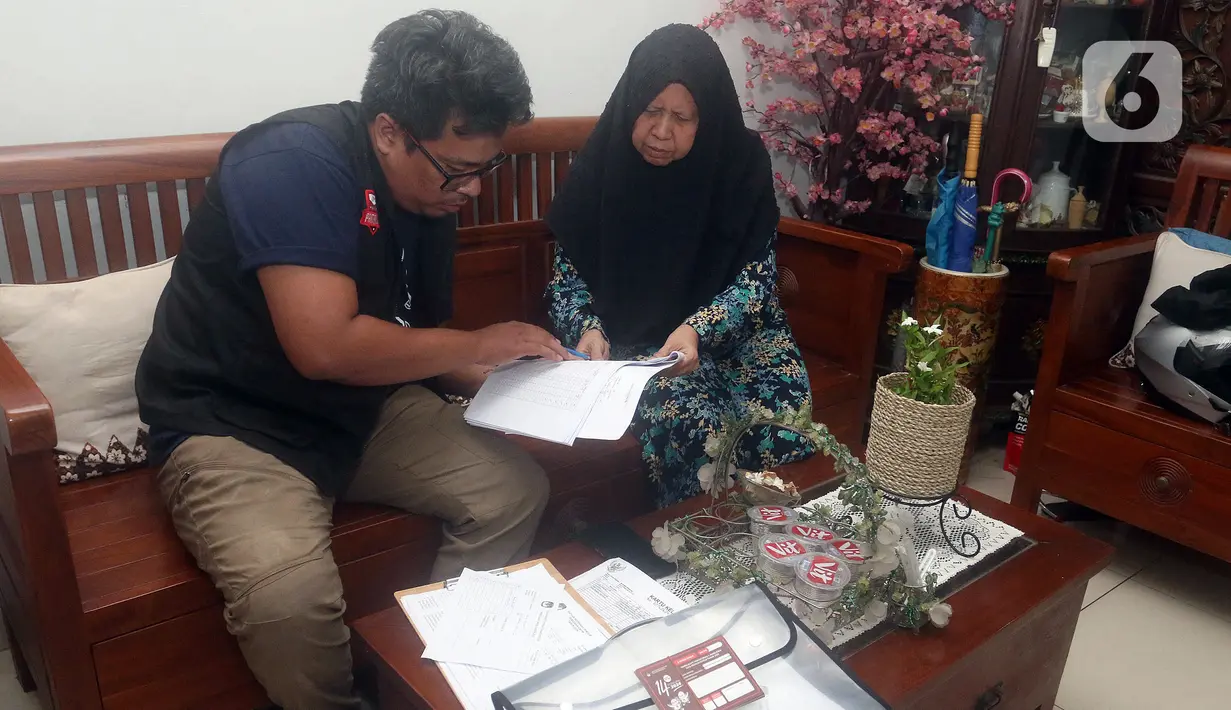 Petugas Pemutakhiran Data Pemilih (Pantarlih) melakukan pencocokan dan penelitian (coklit) data pemilih untuk Pemilu 2024 di rumah warga di Beki, Depok, Jawa Barat, Minggu  (26/2/2023). Pencocokan dan penelitian data pemilih ini dilaksanakan pada 12 Februari sampai 14 Maret 2023. (merdeka.com/Arie Basuki)