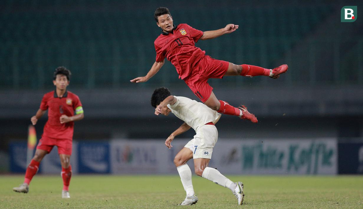 <p>Pemain Timnas Laos U-19, Phonsack Seesavath (atas) berbenturan dengan pemain Timnas Thaliand U-19, Khakana Kamyok saat laga semifinal Piala AFF U-19 2022 yang berlangsung di Stadion Patriot Candrabhaga, Bekasi, Rabu (13/07/2022). (Bola.com/M Iqbal Ichsan)</p>