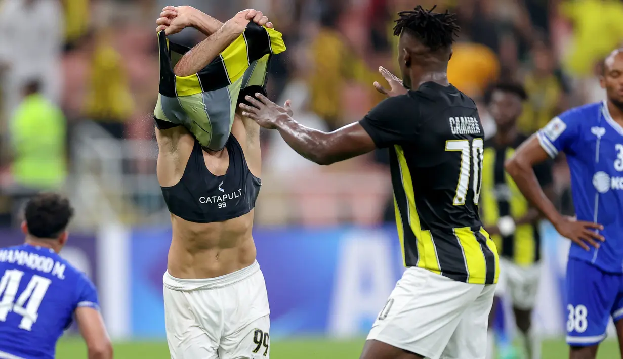 Pemain Al Ittihad, Abderazak Hamdallah melepas jerseynya saat melakukan selebrasi setelah mencetak gol ke gawang Al Quwa Al Jawiya pada laga Grup C Liga Champions Asia 2023 di King Abdullah Sports City, Selasa (24/10/2023) dini hari WIB. Abderazak Hamdallah berhasil mencetak gol pada menit ke-90+4. (AFP)