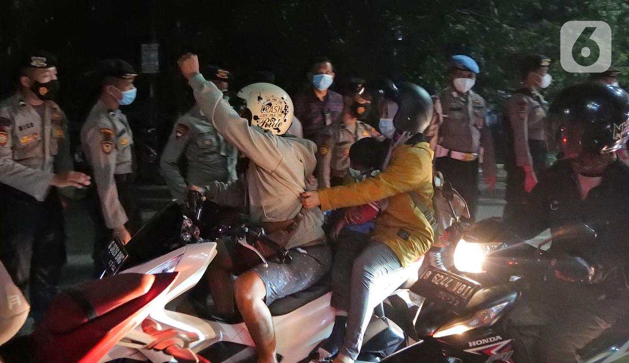 Pemudik motor melewati barisan polisi saat melintas di posko penyekatan mudik di Kedungwaringin, Kabupaten Bekasi, Jawa Barat, Selasa (11/5/2021) dini hari. Bila sudah terjadi penumpukan, kendaraan akan dialirkan ke titik-titik berikutnya. (Liputan6.com/Herman Zakharia)