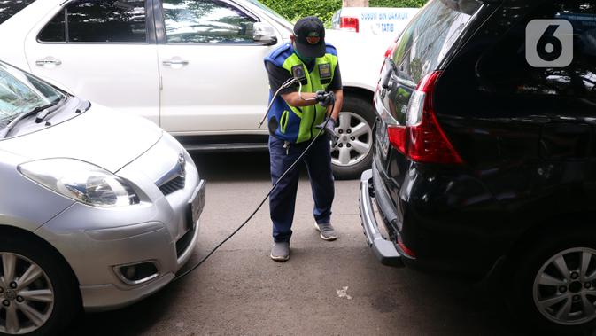 Petugas memeriksa emisi mobil di Jakarta Barat, Rabu (13/1/2021). Dinas Lingkungan Hidup DKI Jakarta mengumumkan kendaraan yang tidak mengikuti uji emisi atau tidak lulus uji emisi gas buang akan dikenakan disinsentif tarif parkir yang tinggi dan tilang. (Liputan6.com/Angga Yuniar)