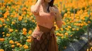 Tampil bak kembang desa, Fuji Utami pilih kebaya Bali peach dengan selendang cokelat di pinggang [@fuji_an]