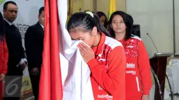 Kapten tim Uber Indonesia, Greysia Polii mencium bendera Merah Putih saat upacara pelepasan di Pelatnas PBSI, Jakarta, Senin (9/5/2016). Piala Thomas dan Uber akan dihelat di Kunshan, Tiongkok, 15-22 Mei mendatang. (Liputan6.com/Helmi Fithriansyah)