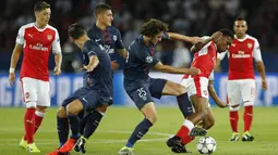 Penyerang Arsenal, Alex Iwobi, berebut bola dengan gelandang PSG, Adrien Rabiot. Tertinggal 0-1 membuat The Gunners langsung berupaya membalikan keadaan. (Reuters/Benoit Tessier)
