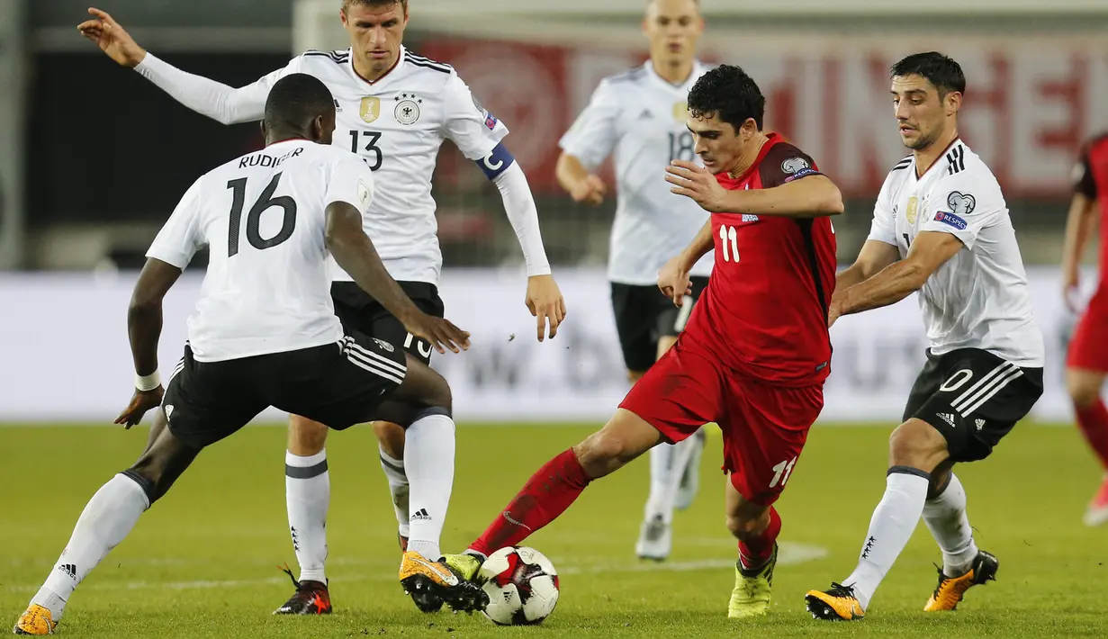 Striker Azerbaijan, Ramil Sheidaev, berusaha melewati pemain Jerman pada laga kualifikasi Piala Dunia di Stadion Fritz Walter, Minggu (8/10/2017). Jerman menang 5-1 atas Azerbaijan. (AP/Michael Probst)