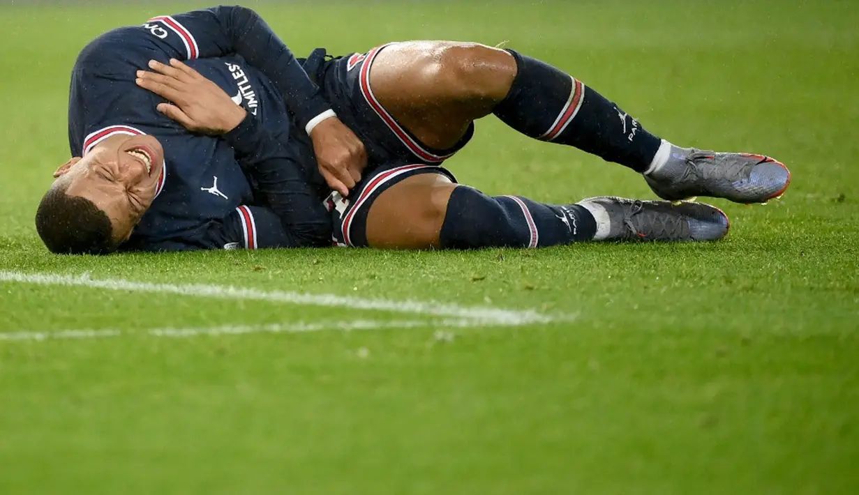 Pemain Paris Saint-Germain Kylian Mbappe bereaksi kesakitan saat melawan Club Brugge pada pertandingan sepak bola Grup A Liga Champions di Parc des Stadion Princes, Paris, Prancis, 7 Desember 2021. Paris Saint-Germain menang 4-1. (FRANCK FIFE/AFP)