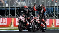 Pembalap MotoGP Italia dari tim Aprilia Racing, Marco Bezzecchi (kanan), merayakan kemenangannya dalam sprint race MotoGP Grand Prix Australia bersama rekan setim sekaligus rekan senegaranya, Lorenzo Savadori, di Phillip Island pada 18 Oktober 2025. (Paul CROCK/AFP)