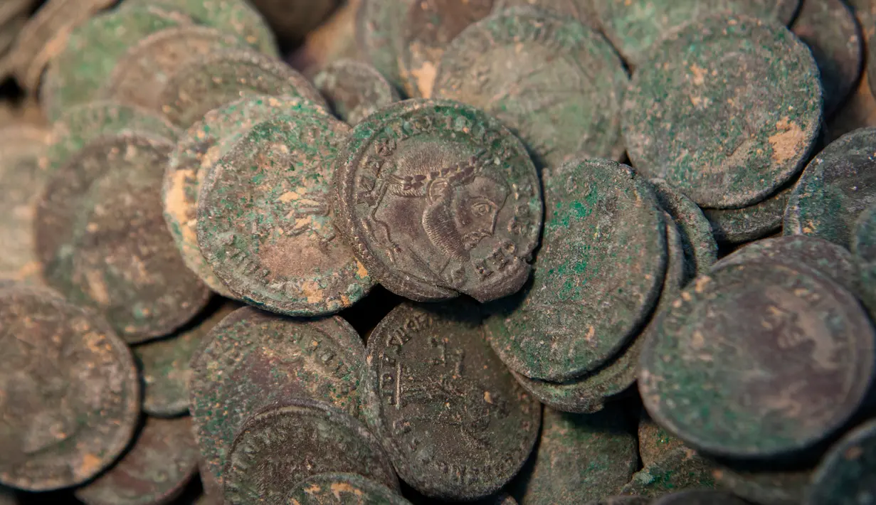 Kumpulan koin kuno Romawi yang diperlihatkan di museum arkeologi di Sevilla, Kamis (28/4). Koin kuno yang memiliki bobot total 600 kg itu ditemukan ketika para pekerja konstruksi  sedang mengerjakan proyek pipa air di Spanyol Selatan. (Gogo Lobato/AFP)