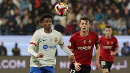 Pemain Barcelona, Alejandro Balde (kiri) berusaha mengontrol bola pada babak semifinal Piala Super Spanyol melawan Osasuna di Stadion Al-Awwal, Riyadh, Arab Saudi, Kamis (11/01/2024). (AFP/Giuseppe Cacace)