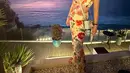 Berada di pantai, Shandy memilih mengenakan dress panjang spaghetti strap cut out dengan gambar bunga-bunga, dipadukan tas Diornya. [@shandyaulia]