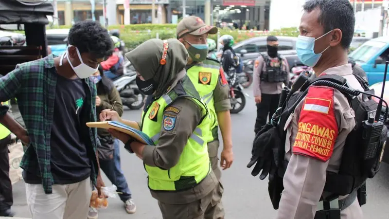 Anggota Satpol PP Kota Depok saat melakukan operasi masker di Kota Depok, Sabtu (26/12/2020)