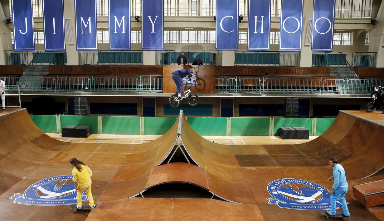 Sejumlah model pria menggunakan sepeda dan skatebord saat tampil memperagakan busana dan aksesoris karya Jimmy Choo di London, Inggris, Senin (15/6/2015). (REUTERS/Suzanne Plunkett)