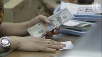 Teller menghitung mata uang dolar di penukaran uang di Jakarta, Jumat (20/4). Nilai tukar rupiah terhadap dolar AS pagi ini melemah ke posisi di Rp 13.820. (Liputan6.com/Angga Yuniar)