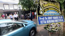 Karangan bunga  dari Ketua MK, Arief Hidayat terlihat diletakkan di depan rumah duka Menteri KKP, Susi Pudjiastuti, di Jakarta, Senin (18/1/2016). Putra sulung Menteri  Susi, Panji Hilmansyah, meninggal dunia di Amerika Serikat.(Liputan6.com/Helmi Afandi)