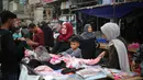 Sebagaimana diketahui, Badan Bantuan dan Pekerjaan PBB untuk pengungsi palestina, UNRWA telah mengumumkan 1,9 juta orang telah mengungsi secara paksa di Jalur Gaza Palestina. Tampak dalam foto, warga Palestina yang mengungsi berbelanja pakaian di pasar jalanan sekitar kamp pengungsi Nuseirat, Jalur Gaza tengah, pada Rabu 18 Maret 2026. (Eyad Baba/AFP)
