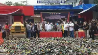 Polres Metro Tangerang Kota menghancurkan ribuan botol minuman keras menggunakan buldozer, Rabu (30/3/2022). (Foto:Liputan6/Pramita Tristiawati)
