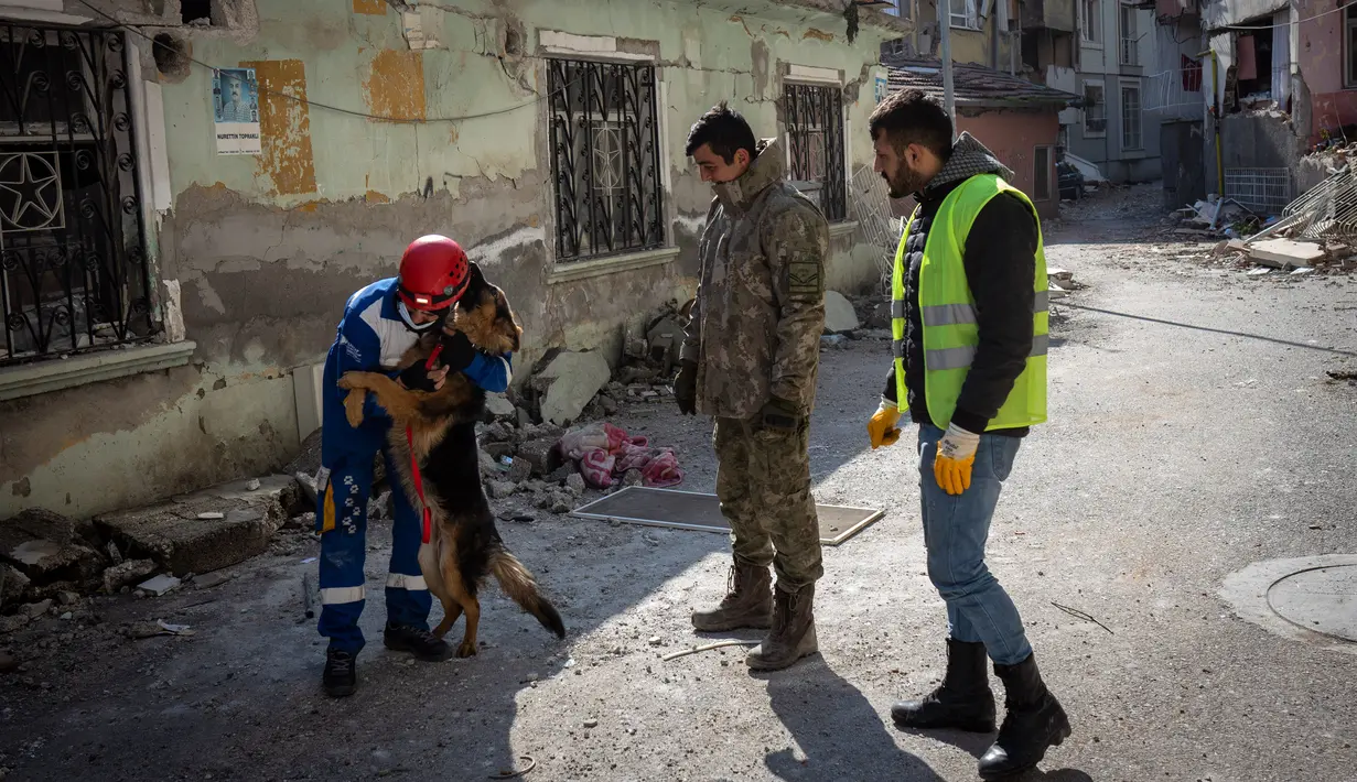 Anggota kelompok hak asasi hewan Turki, HAYTAP, Mehmet Gurkan memeluk seekor anjing setelah menyelamatkannya dari sebuah bangunan yang terkena dampak gempa di Antakya, Turki, 12 Februari 2023. Anjing gembala Jerman itu diselamatkan setelah terjebak selama tujuh hari di dalam gedung yang terkena dampak gempa. (AP Photo/Bernat Armangue)
