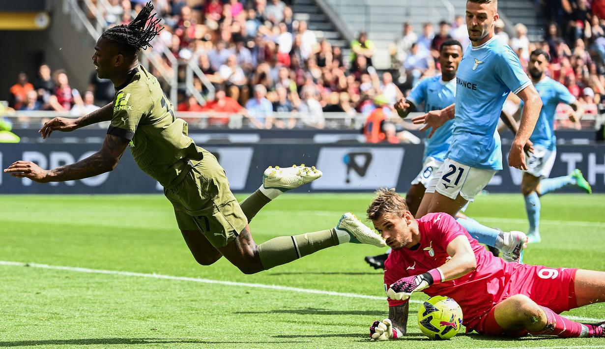 <p>Pemain AC Milan, Rafael Leao (kiri) terjatuh saat berusaha melewati kiper Lazio, Ivan Provedel pada laga pekan ke-34 Liga Italia 2022/2023 antara AC Milan melawan Lazio di San Siro, Milan, Italia, Sabtu (06/05/2023). (AFP/Isabella Bonotto)</p>