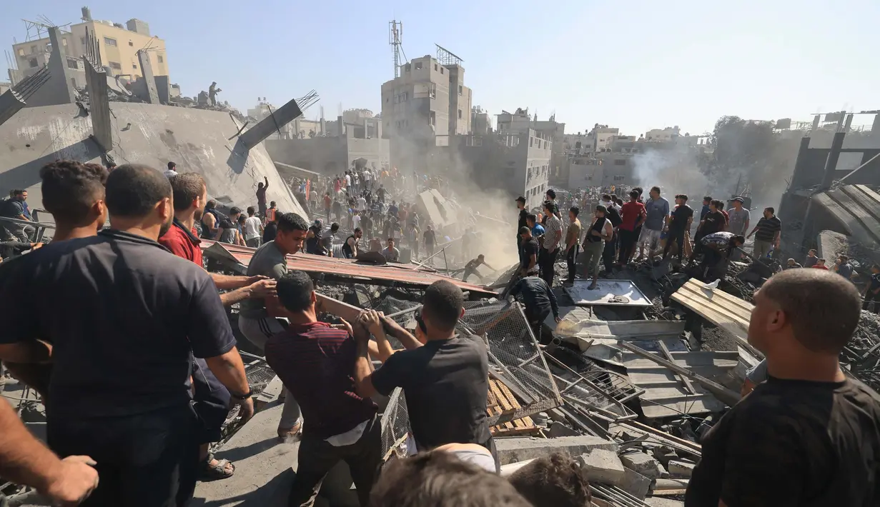 Warga Palestina melakukan pencarian korban diantara puing-puing bangunan yang hancur akibat pengeboman Israel secara manual. (Mahmud HAMS/AFP)