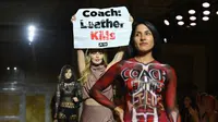 Seorang aktivis Peta memegang tanda bertuliskan "Coach: Leather Kills" saat ia berdemonstrasi di runway di show Coach Spring 2024 selama New York Fashion Week di New York City pada 7 September 2023. (ANGELA WEISS / AFP)