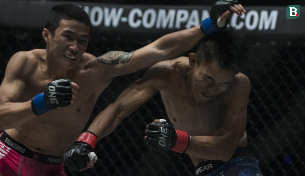 Atlet MMA Indonesia, Stefer Rahardian, menghindari pukulan atlet MMA China, Peng Xue Wen, pada kelas strawweight di JCC Senayan, Jakarta, Sabtu (22/9/2018). Stefer Rahardian kalah dari Peng Xue Wen. (Bola.com/Vitalis Yogi Trisna)