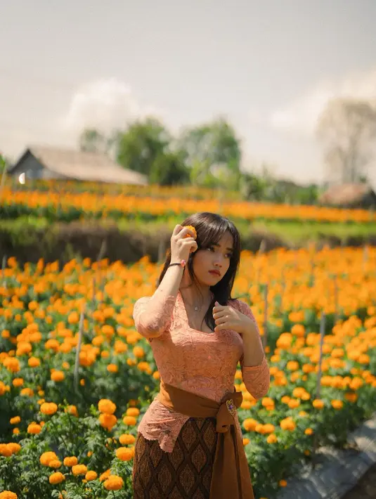 Cantiknya Fuji saat mengenakan kebaya di tengah kebun bunga. Kebaya pink dipadu dengan kain batik cokelat yang serasi dengan selendang tipisnya membalut tubuh Fuji dengan amat baik. [Foto: Instagram/fuji_an]